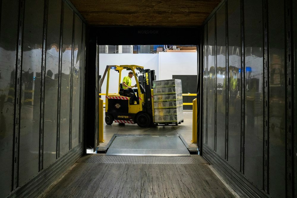 Operarios de H&A retirando carga paletizada de un camión con autoelevador